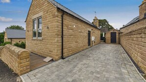 A stone building with a pitched roof and a small window. - Oakwood Lodge (Matlock)