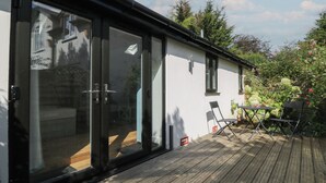 A house with a sliding glass door leading to a wooden deck. - 2 Welford Barns (Fordingbridge)