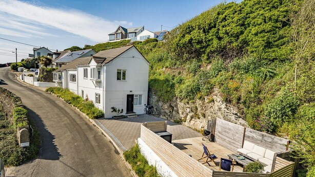 A coastal property with a white house, a wooden deck, and a paved driveway. - Fairwinds (Redruth)