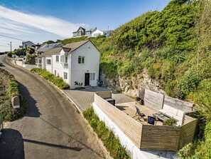 A coastal property with a white house, a wooden deck, and a paved driveway. - Fairwinds (Redruth)