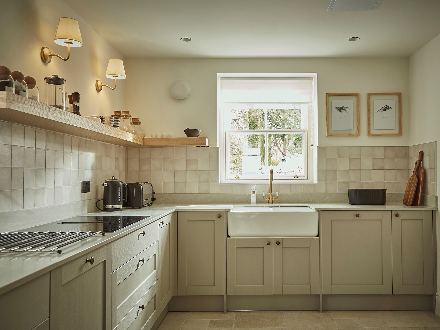 A modern kitchen with a central island, a built-in oven, and a large window providing natural light.