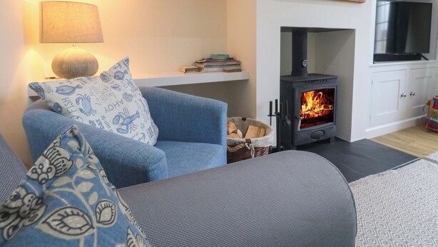 A living room with a sofa, a lamp, a fireplace, and a TV. - Fair View (Truro)