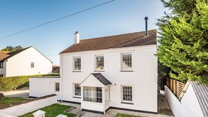 A two-story white house with a sloped roof, a small front porch, and a visible chimney. - Fair View (Truro)