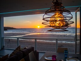 Un comedor con vista a la playa y al atardecer.