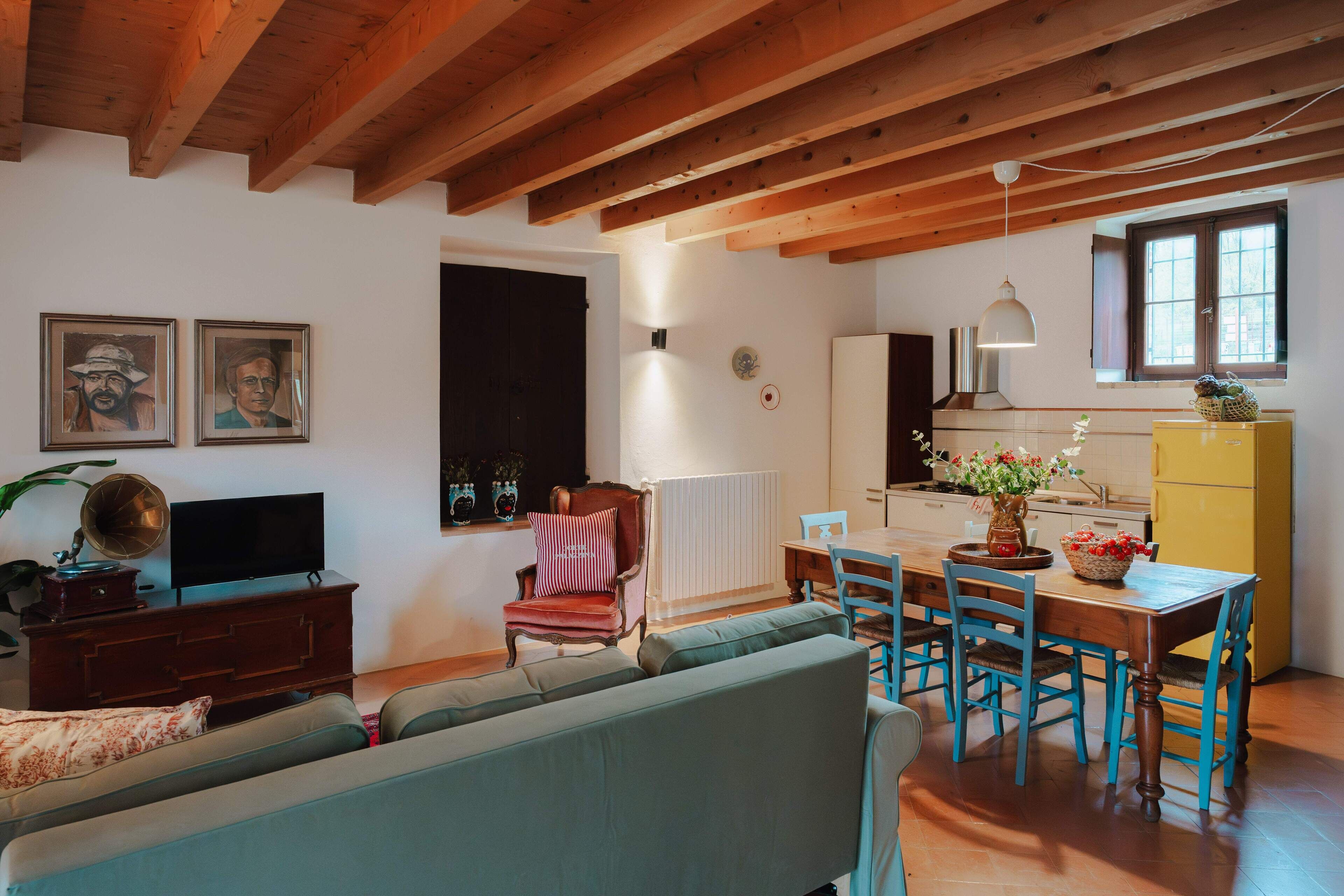 Una sala de estar acogedora con un sofá, televisión y un comedor con mesa y sillas.