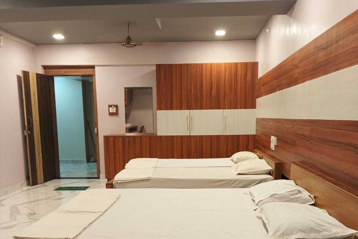 A bedroom with a large bed, wooden headboard, and a small bedside table.