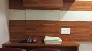 Une petite cuisine compacte, dotée d’un plan de travail en bois, de deux chaises et d’un évier.