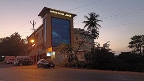 Un bâtiment sur lequel on peut lire l’inscription « Shree Ratna Lodge » au crépuscule.