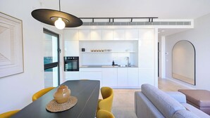 Een moderne keuken met witte kasten, een ingebouwde oven en een centraal eiland.