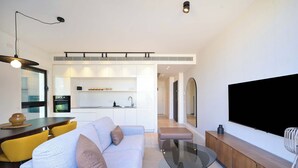 Een moderne woonkamer met een bank, salontafel en een flatscreen televisie.