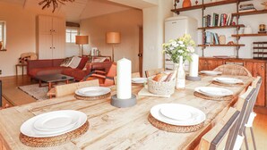 A dining area with a wooden table set for four, surrounded by wicker chairs. - Roughtor Barn (Camelford)