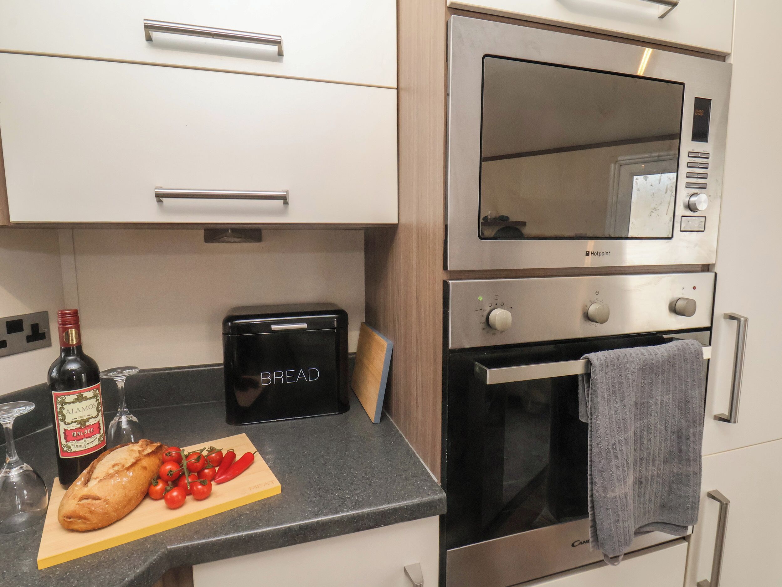 Een keuken met een broodmachine, een broodrooster en een dubbele oven.