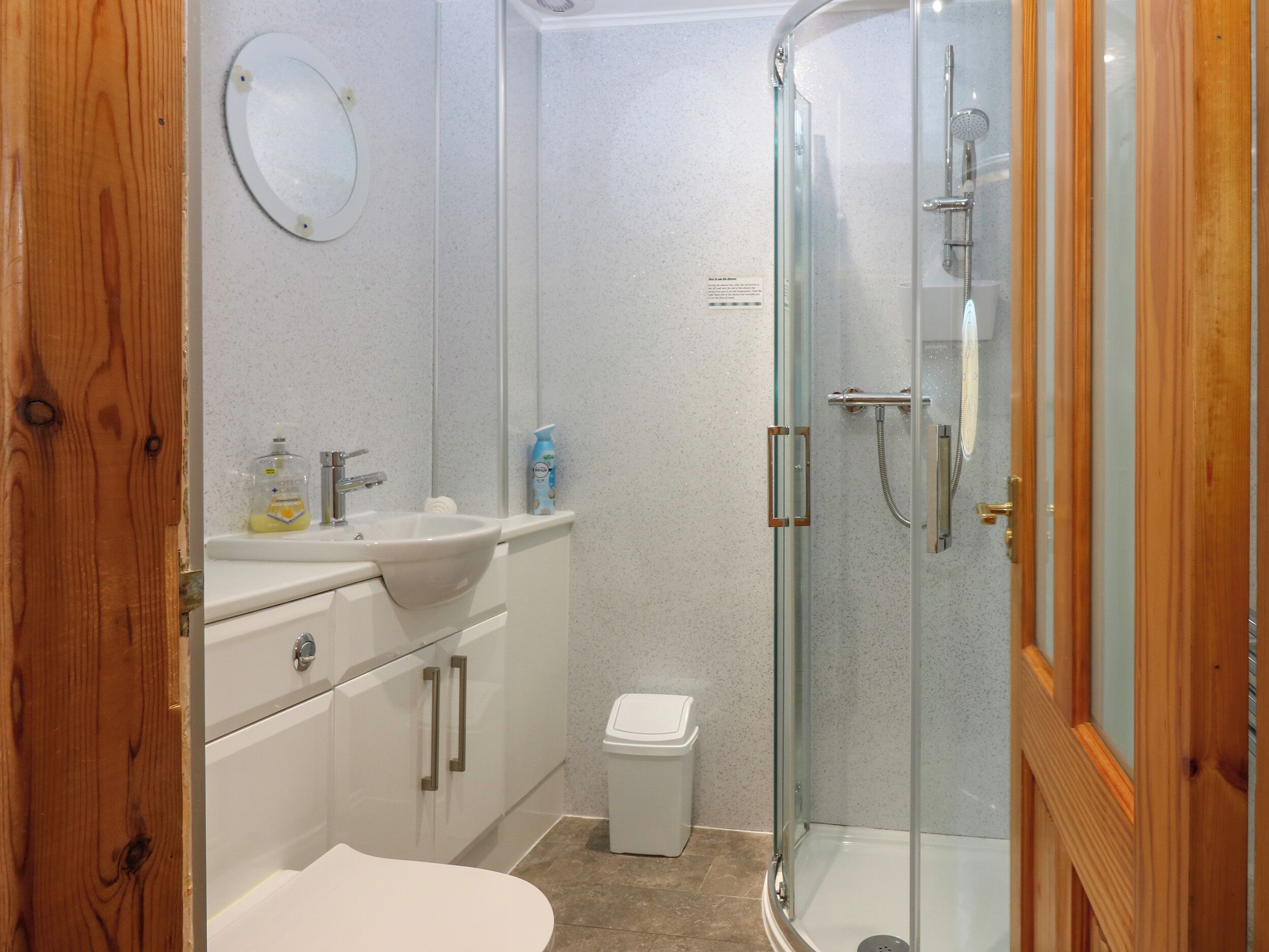 A bathroom with a sink, toilet, and glass-enclosed shower.