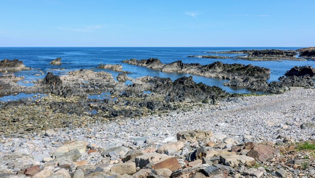 A rocky shoreline with a clear blue sky. - Jade Cottage (Macduff)