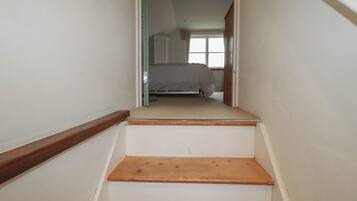 Un escalier étroit avec des marches en bois menant à une chambre.