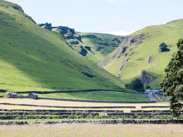 A rural landscape with rolling hills, stone walls, and a small building. - Buttercup Cottage (Hope Valley)