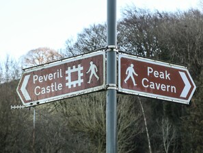 A directional sign with arrows pointing to 'Peveril Castle' and 'Peak Cavern'. - Buttercup Cottage (Hope Valley)
