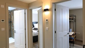 A hotel room with a shower, a bed, a desk, and a chair.