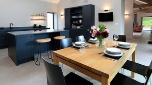 A modern kitchen with dark cabinetry, a central island, and bar stools.