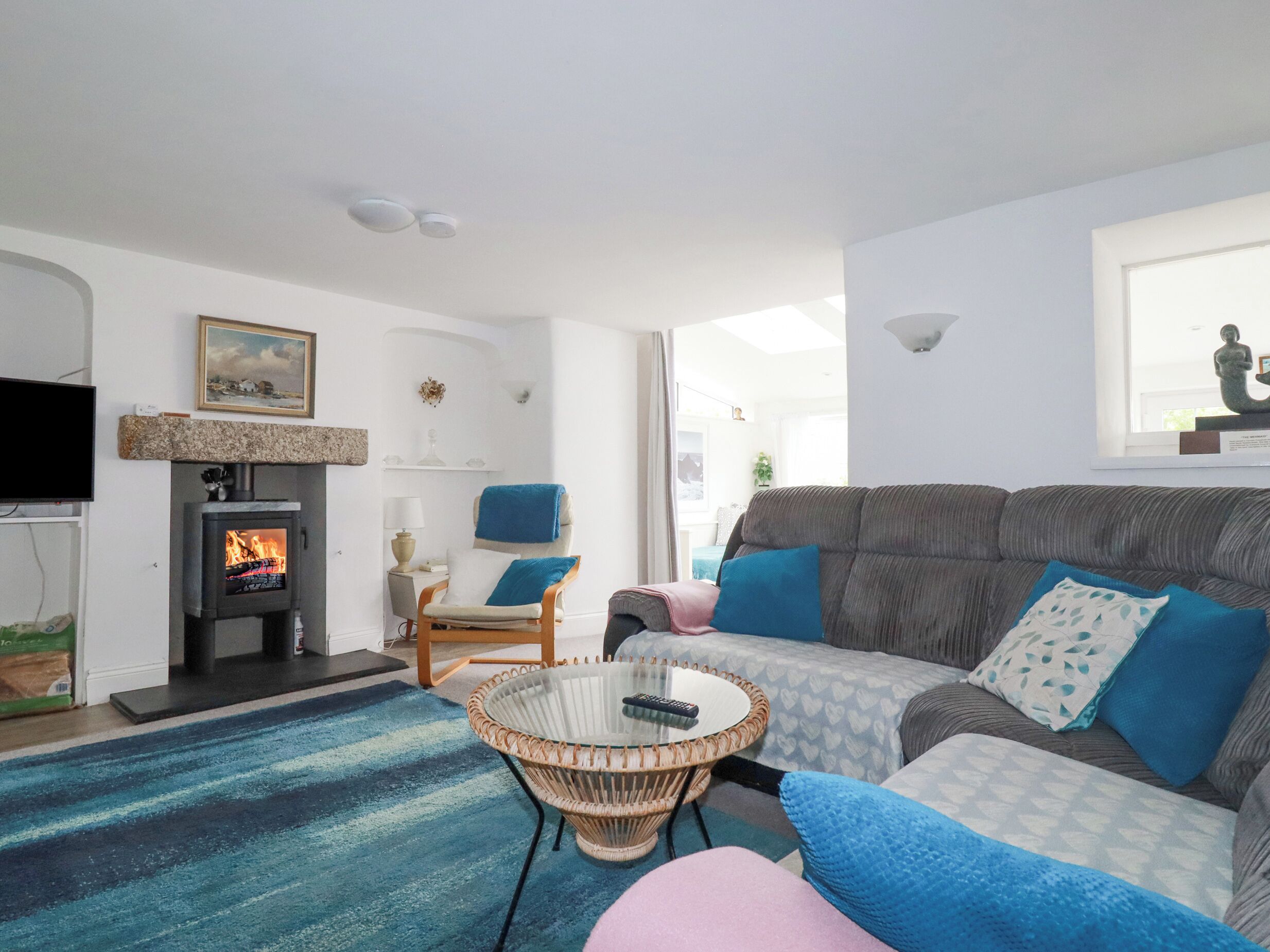 A living room with a fireplace, a sofa, a chair, and a round table.
