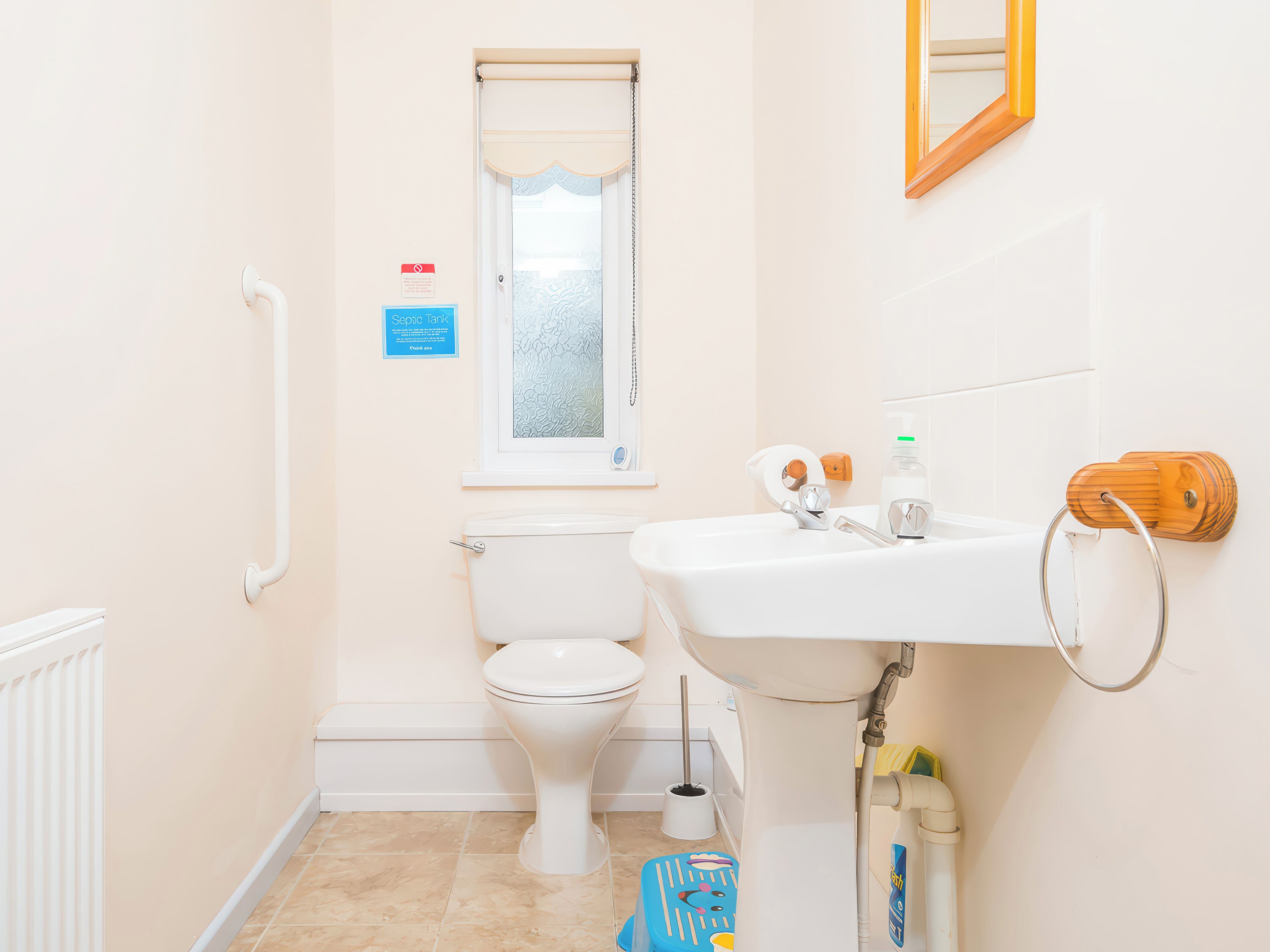 A small, clean bathroom with a toilet, sink, and window.