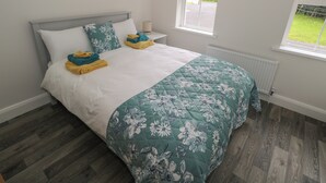 A bedroom with a bed, a nightstand, a window, and a view of the outdoors. - Ciara's Place (Riverstown)
