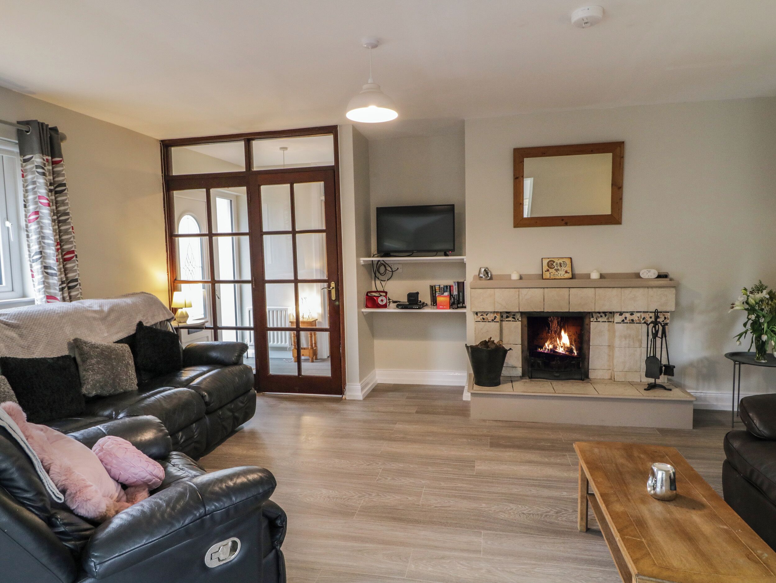 Ein Wohnzimmer mit Kamin, Fernseher und Sofa.