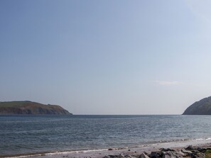 A coastal landscape with a rocky beach and calm sea.
