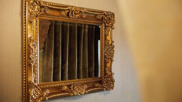 A wall-mounted mirror with an ornate gold frame.
