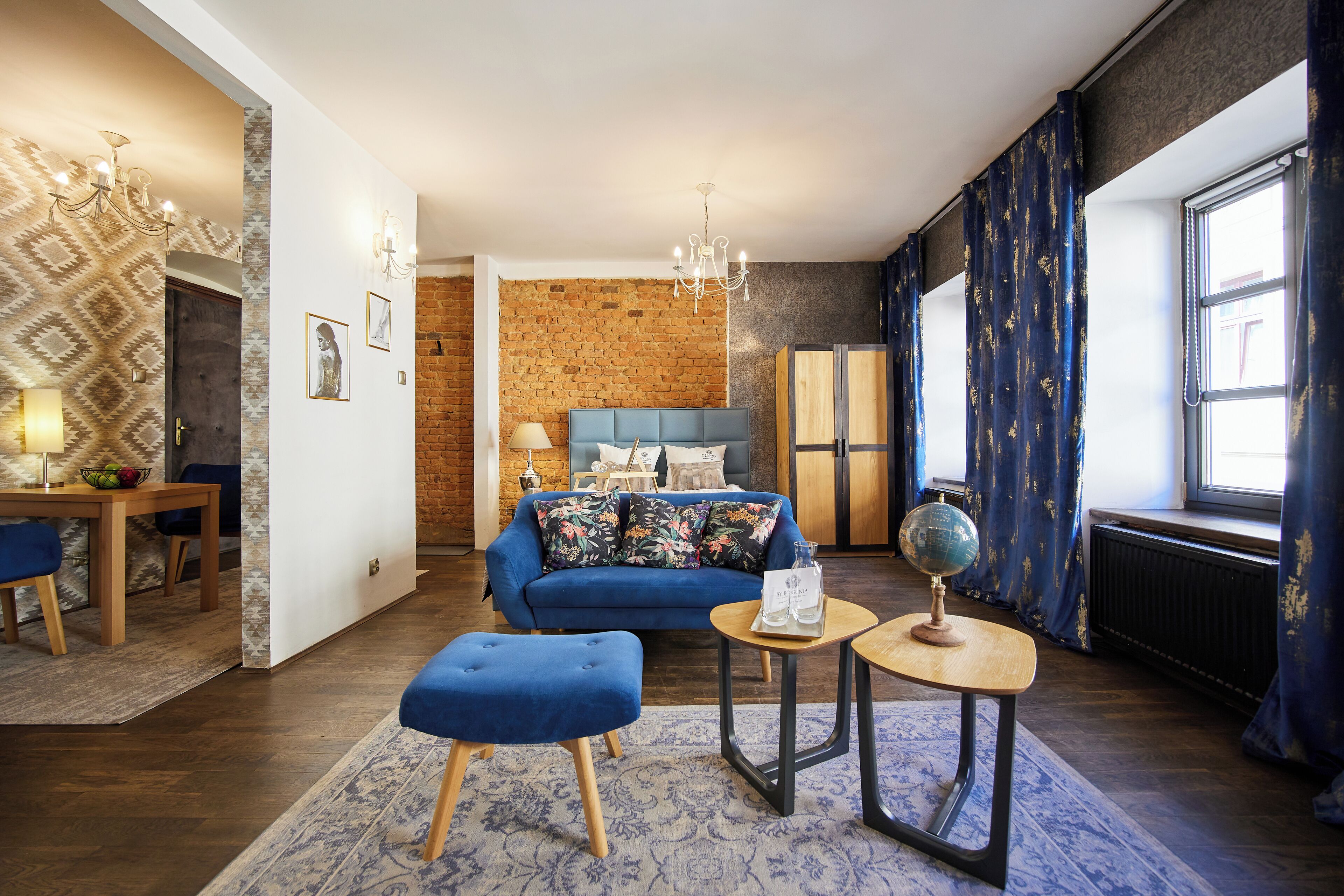 Een moderne woonkamer met een blauwe bank, een houten salontafel en een wereldbol.