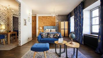 Een moderne woonkamer met een blauwe bank, een houten salontafel en een wereldbol.