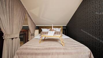 A bedroom with a bed, a tray with a bottle and glasses, and a patterned wall.