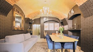 A dining area with a wooden table, blue chairs, a chandelier, and patterned walls. - Apartamenty By Bogunia (Bielsko-Biala)
