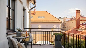 A balcony with a table, chairs, and a potted plant. - Apartamenty By Bogunia (Bielsko-Biala)