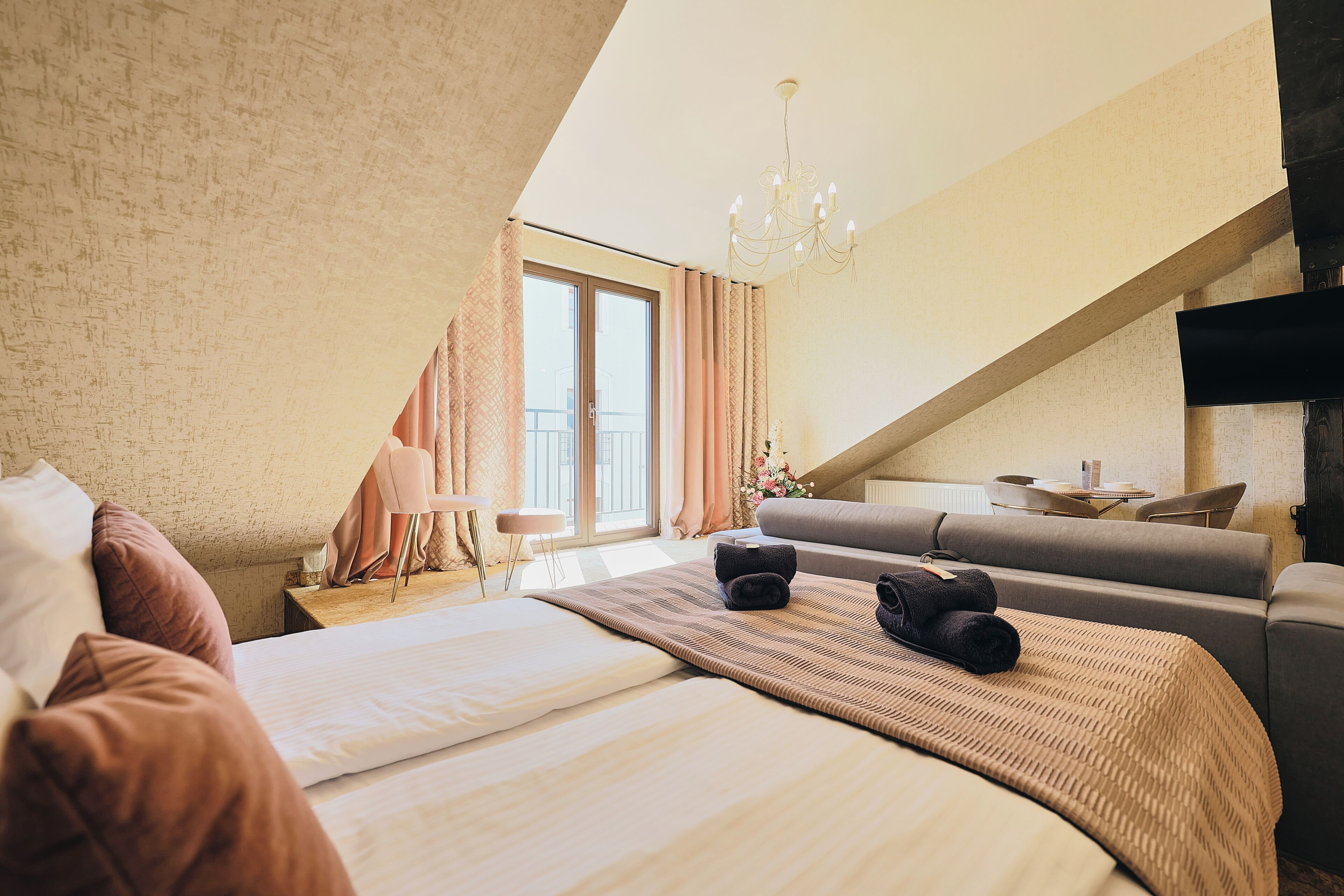 Ein Hotelzimmer mit einem großen Bett, einer Couch, einem Schreibtisch und einem Fernseher.