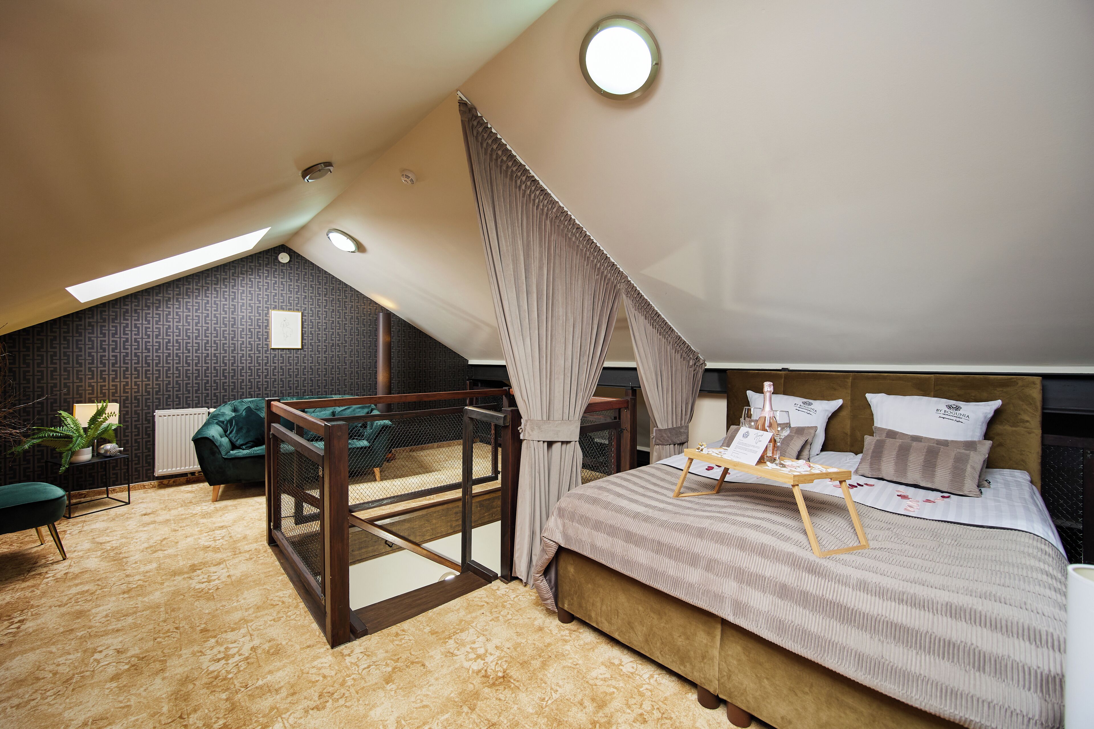Un dormitorio estilo loft moderno con techo inclinado, una cama grande con dosel, una mesita con bandeja y vistas a la ciudad.
