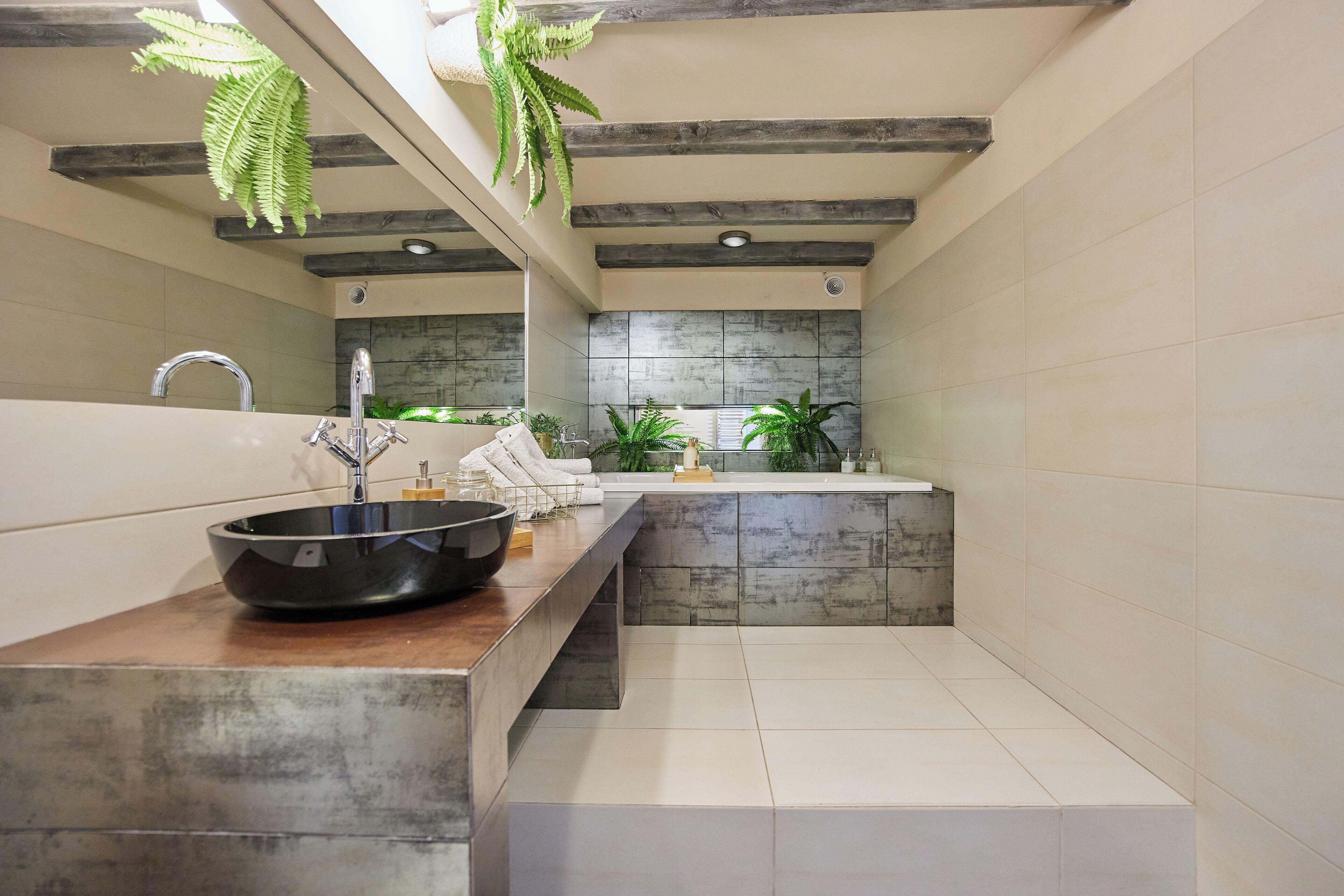 Ein modernes Badezimmer mit einem großzügigen Waschbecken, einer Holzauslage und einer Steinwandverkleidung.