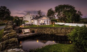 A house with a stone wall, a pond, and a hammock. - River Barn (Grange-over-Sands)