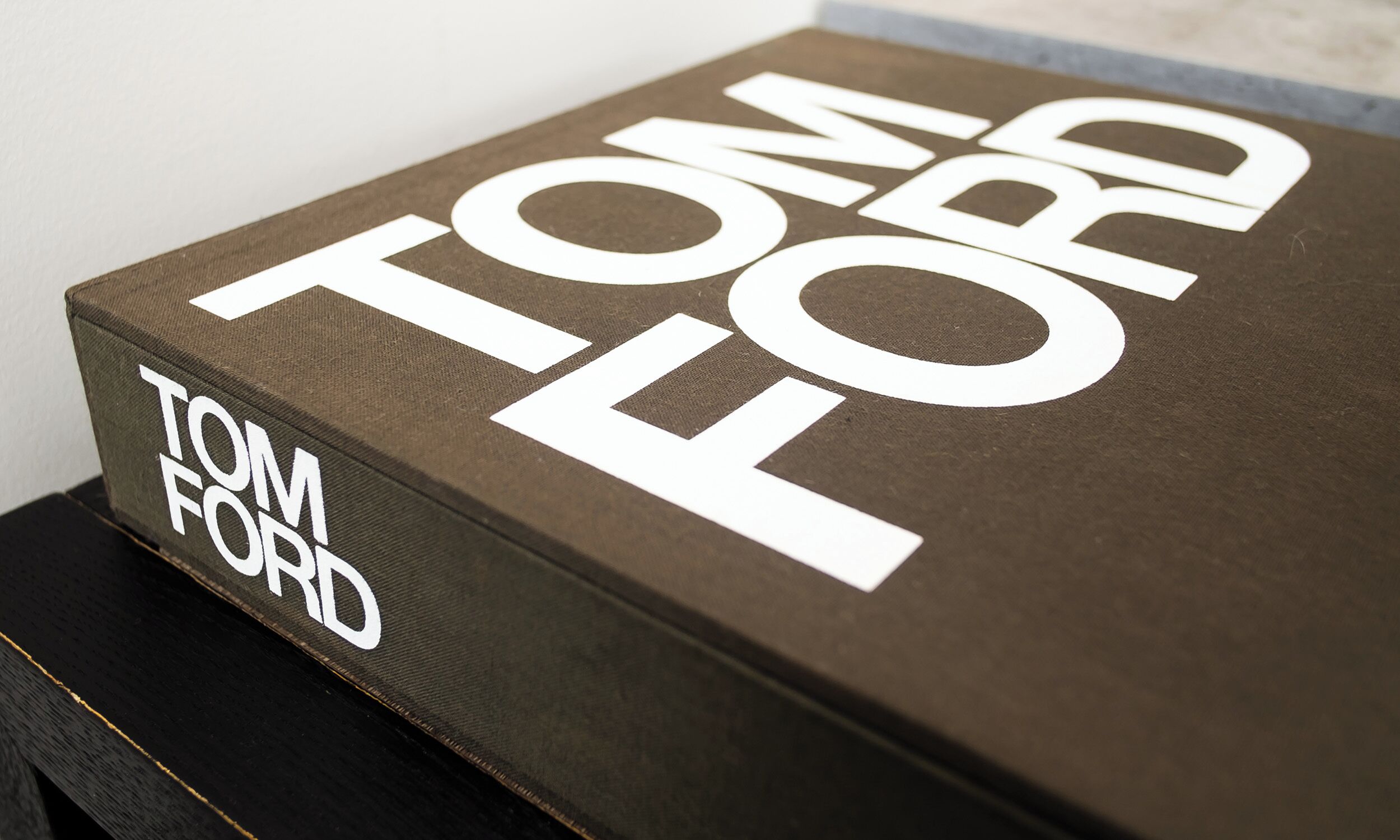 Un libro con el título "TOM FORD", de cubierta oscura y texto blanco.
