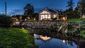 A house with a stone wall and a pond in front. - River Barn (Grange-over-Sands)