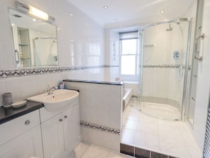 A modern bathroom with a glass-enclosed shower, a sink with a mirror, and a window providing natural light. - Two Tweenways (Ambleside)
