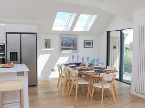 Una cocina moderna con comedor, tragaluces y vistas al exterior.