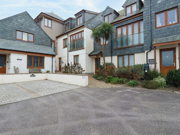 A residential building with multiple units, each featuring a balcony and a small garden area. - Blue Horizon (Port Isaac)