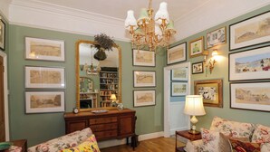 Una sala acogedora con tapicería floral, un mueble de madera y un espejo grande.