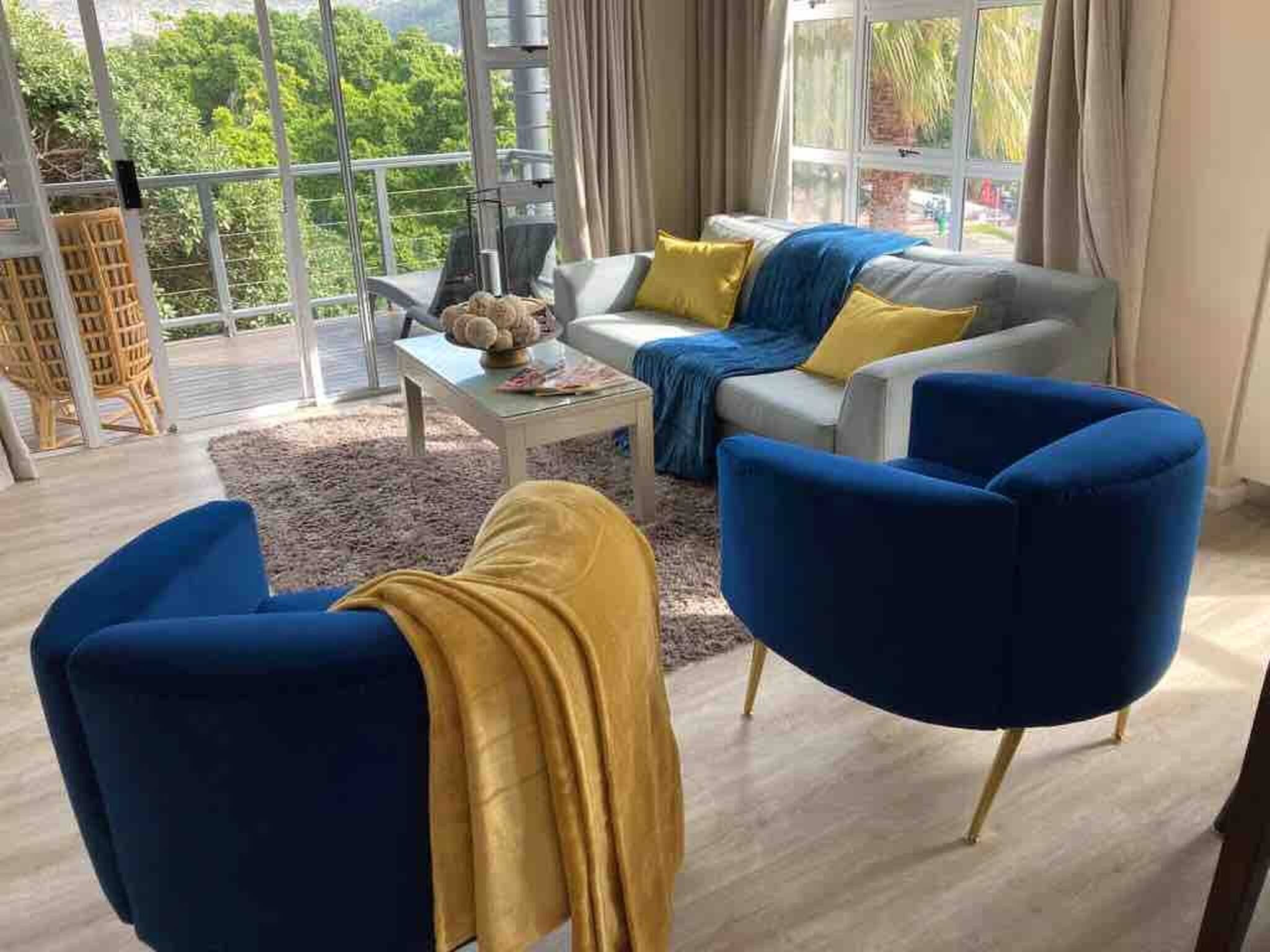 A modern living room with a sofa, two armchairs, and a coffee table.