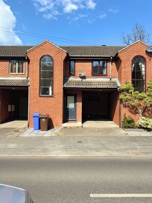 En tofret murstensbygning med garage, store vinduer og en parabol.