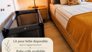 A bedroom with a bed, bedside lamp, and decorative wall hangings. - •V.I.P Stay - Downtown with Free Indoor Parking (Québec)