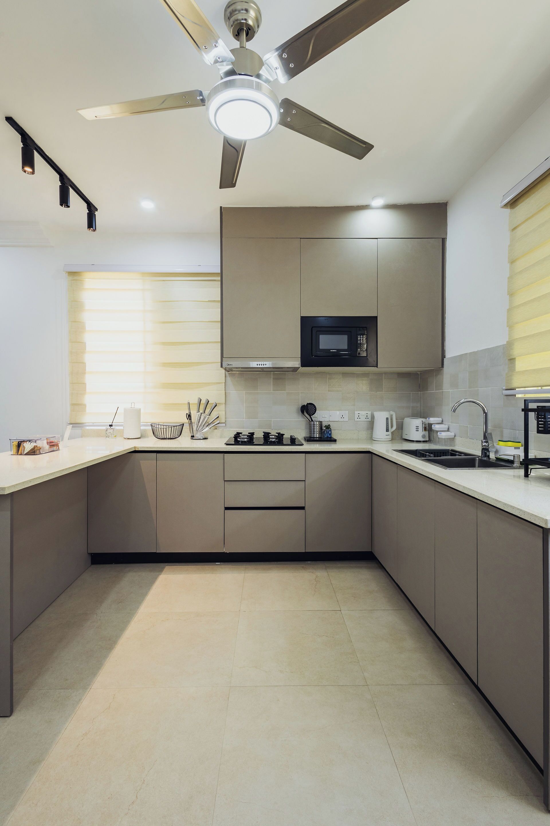 A modern kitchen with a ceiling fan, built-in microwave, and stainless steel appliances.
