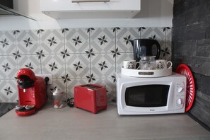 A kitchen with a microwave, toaster, and coffee maker on the counter.