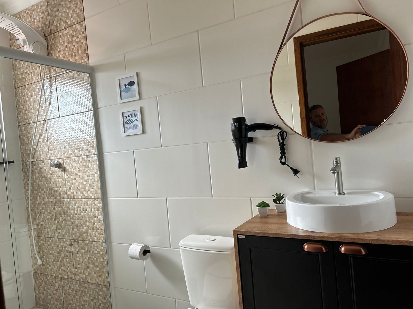 Un baño con lavamanos blanco, un espejo y una ducha.